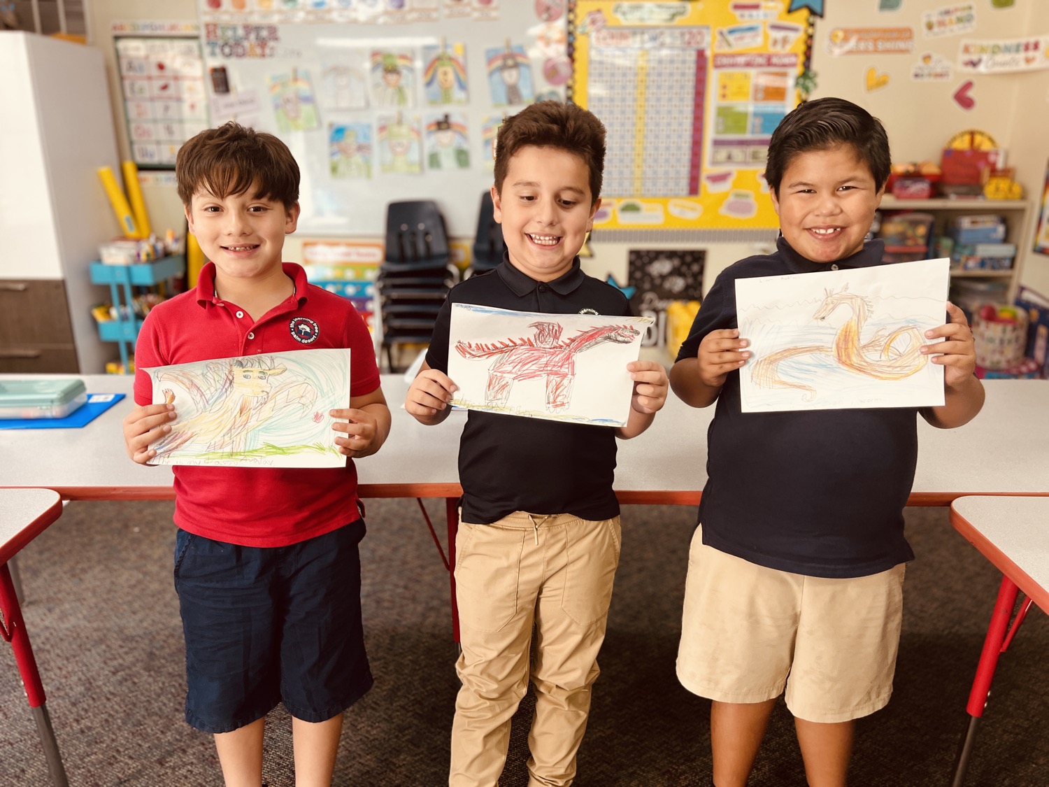 Learning Tree students proudly holding dragon drawings they made in class