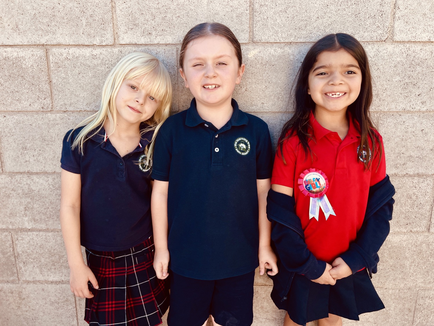 Three Learning Tree students in uniform smiling together