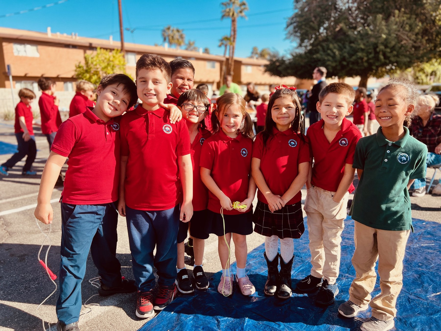 Learning Tree students in red uniforms smiling together on the Palm Desert campus
